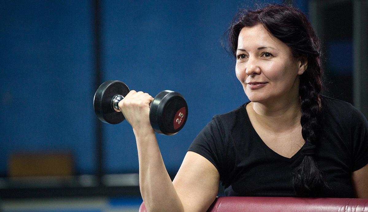 woman lifting dumbbell in a bicep curl