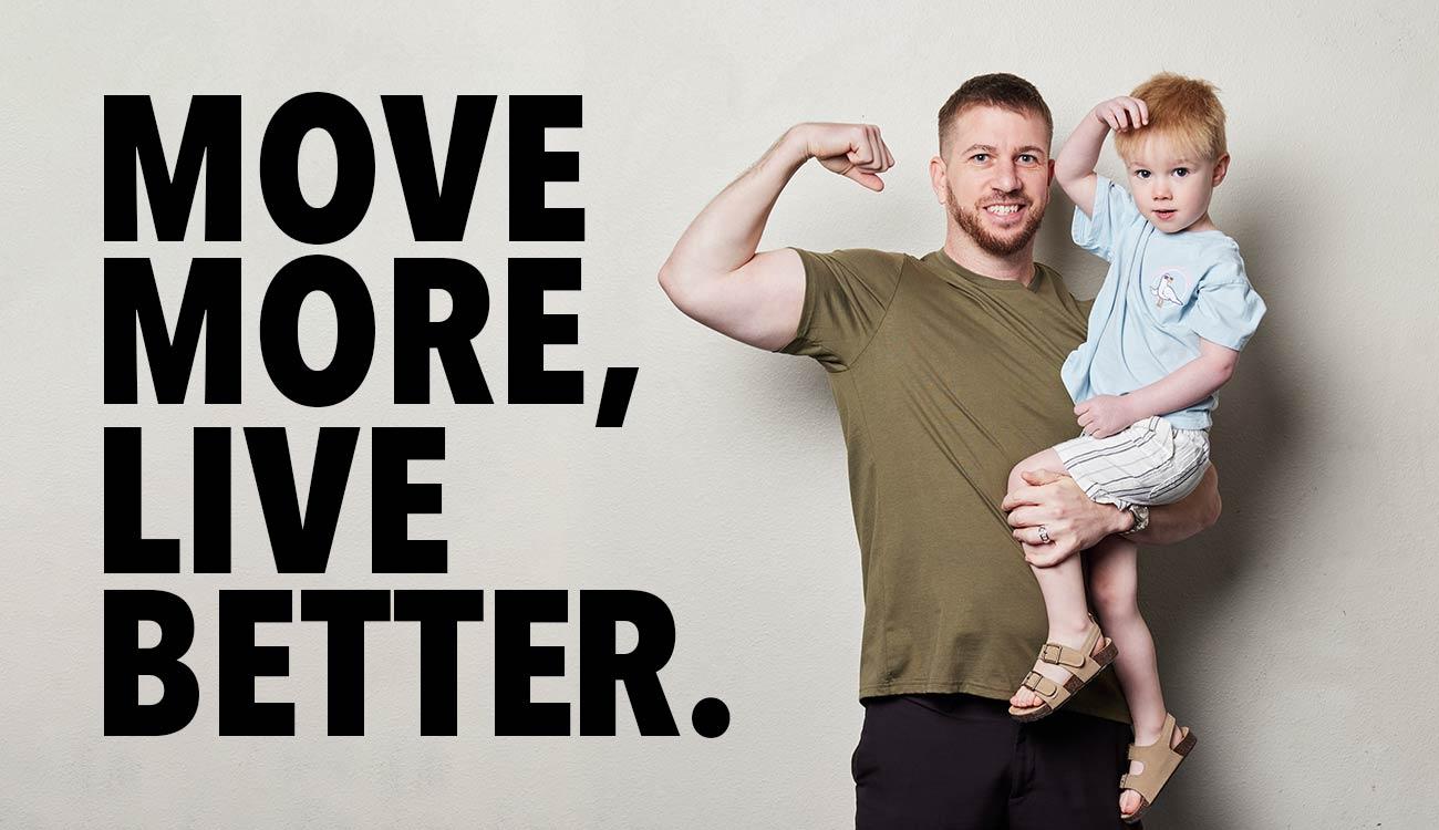 Man holding son in one arm and flexing other arm